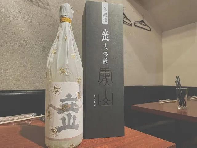 笑緒一の店内。日本酒の瓶が並ぶ客席とカウンター